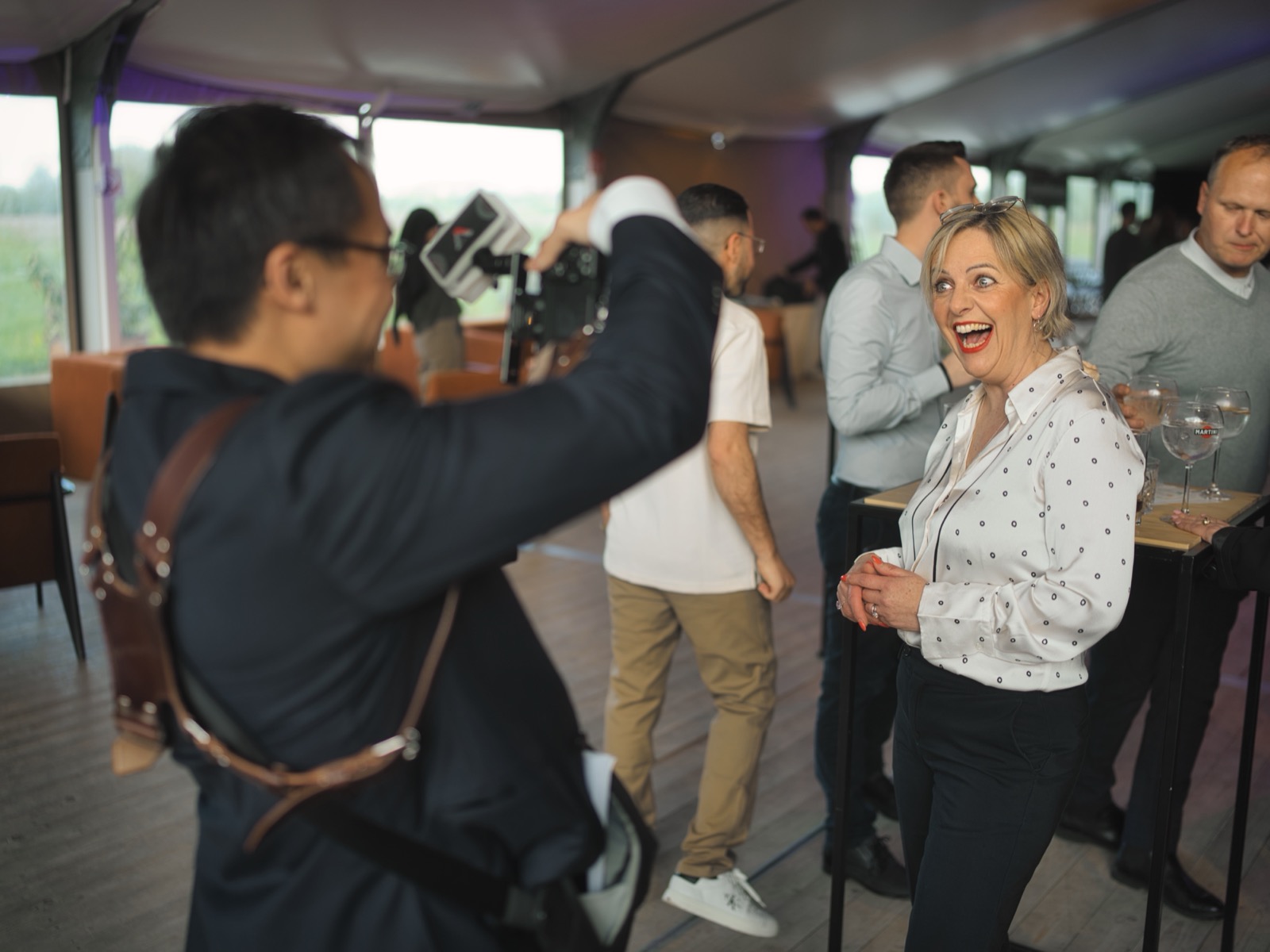 Une invitée éclate de rire, émerveillée, pendant que le PhotoMentaliste déclenche